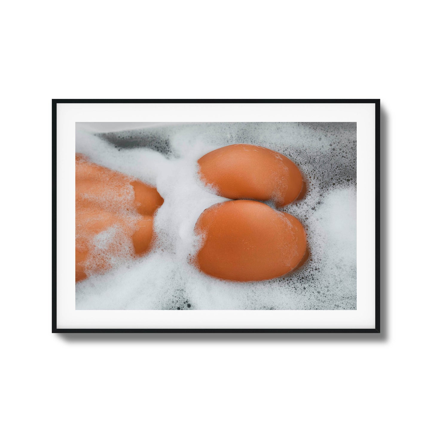 Close-up of skin and foam in a bathtub.