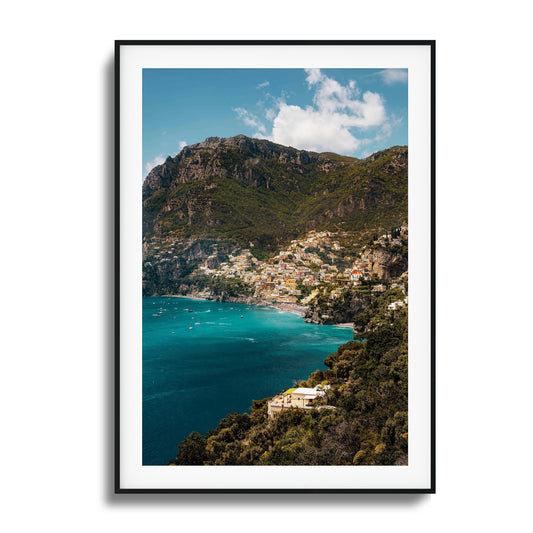 View of colorful Amalfi Coast houses nestled into dramatic cliffs with turquoise waters.