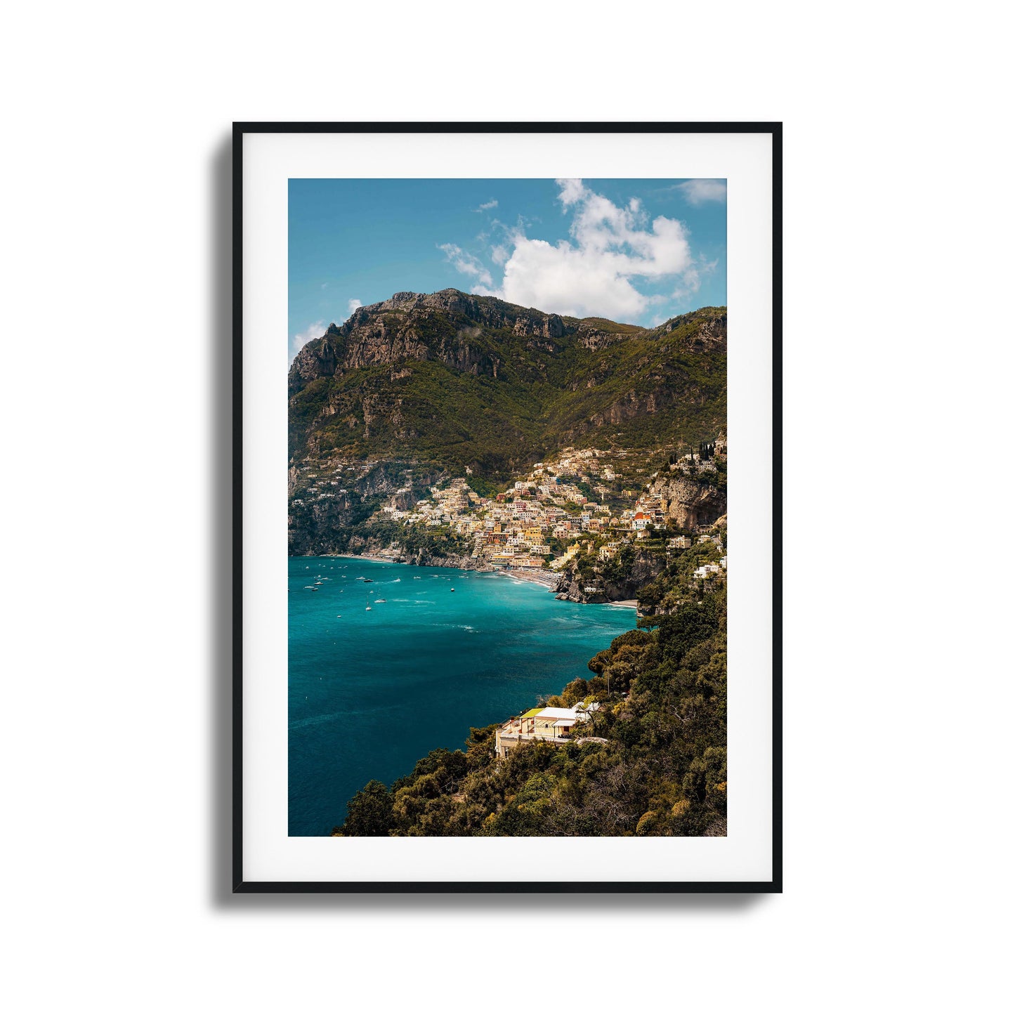 View of colorful Amalfi Coast houses nestled into dramatic cliffs with turquoise waters.