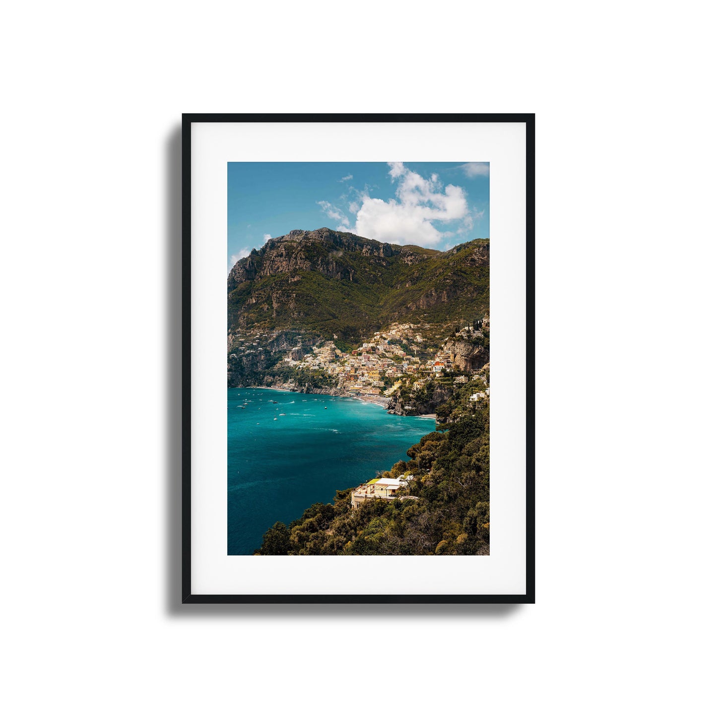 View of colorful Amalfi Coast houses nestled into dramatic cliffs with turquoise waters.