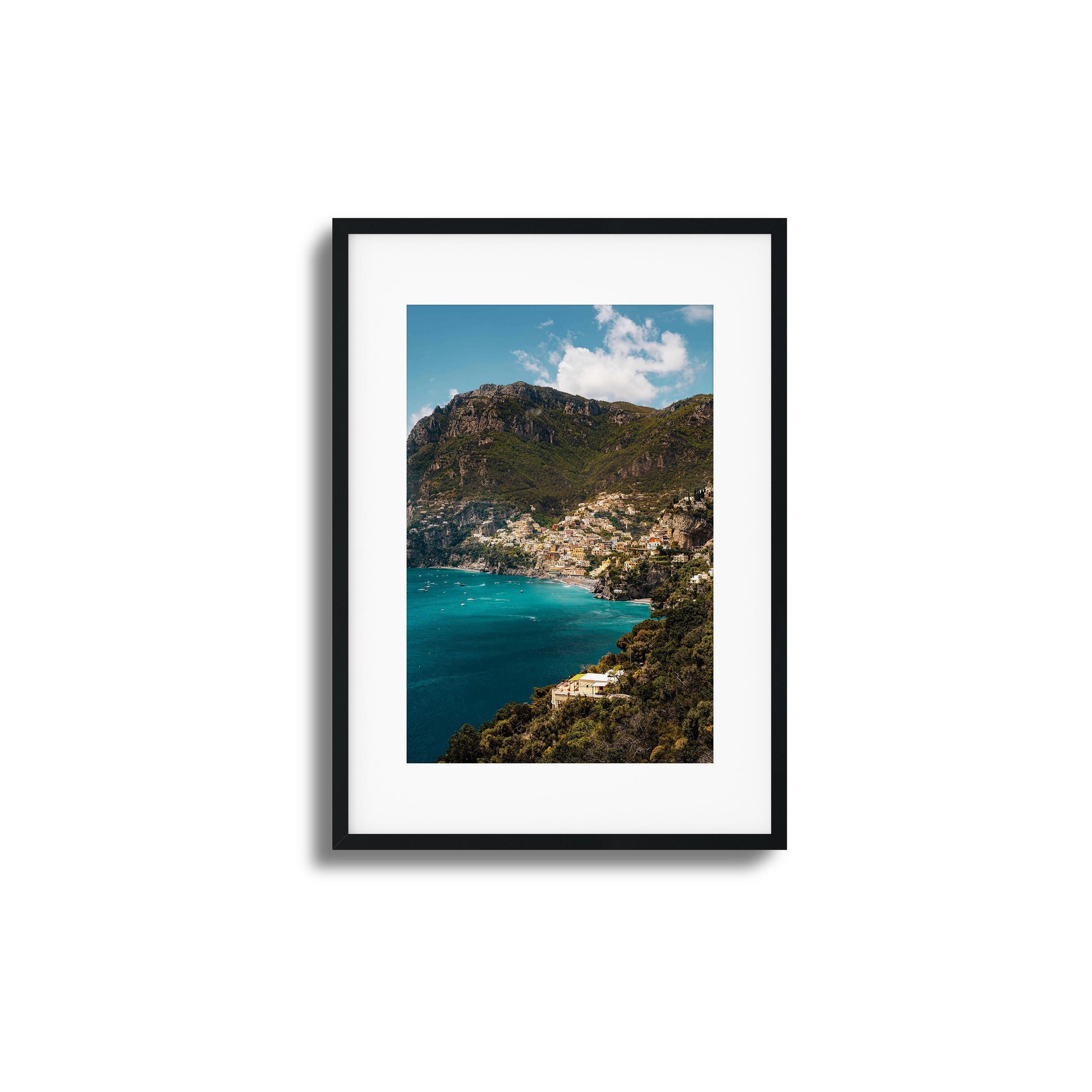 View of colorful Amalfi Coast houses nestled into dramatic cliffs with turquoise waters.