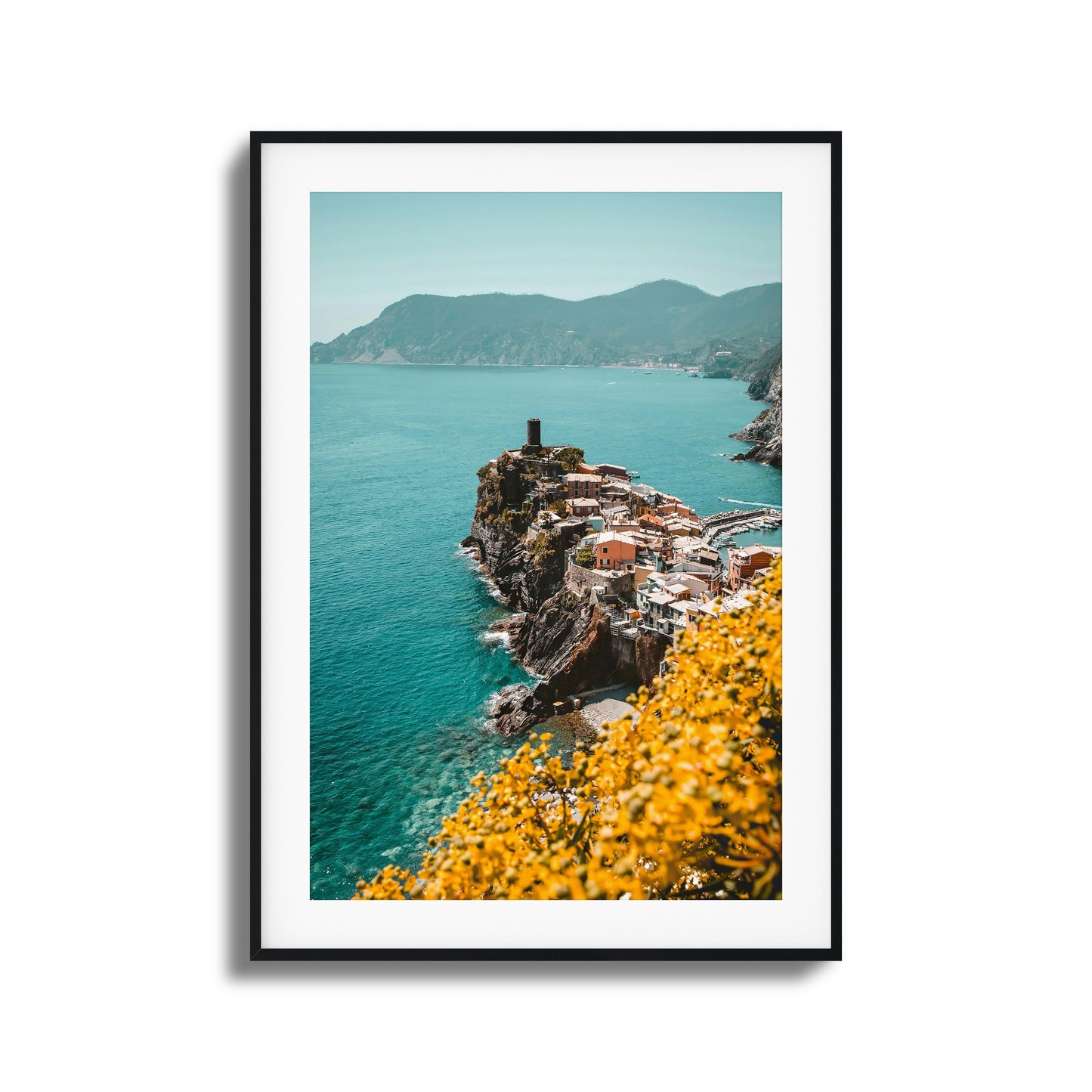 Coastal village on a cliff with turquoise waters and yellow flowers