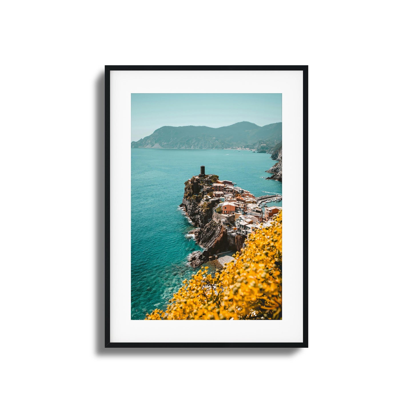 Coastal village on a cliff with turquoise waters and yellow flowers