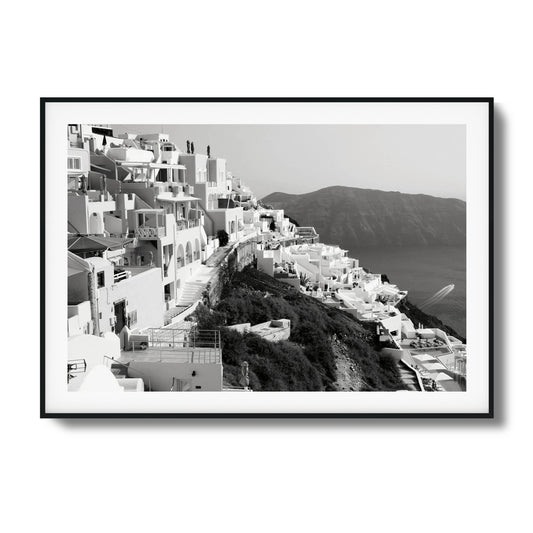 Black-and-white image of white hillside buildings overlooking the sea