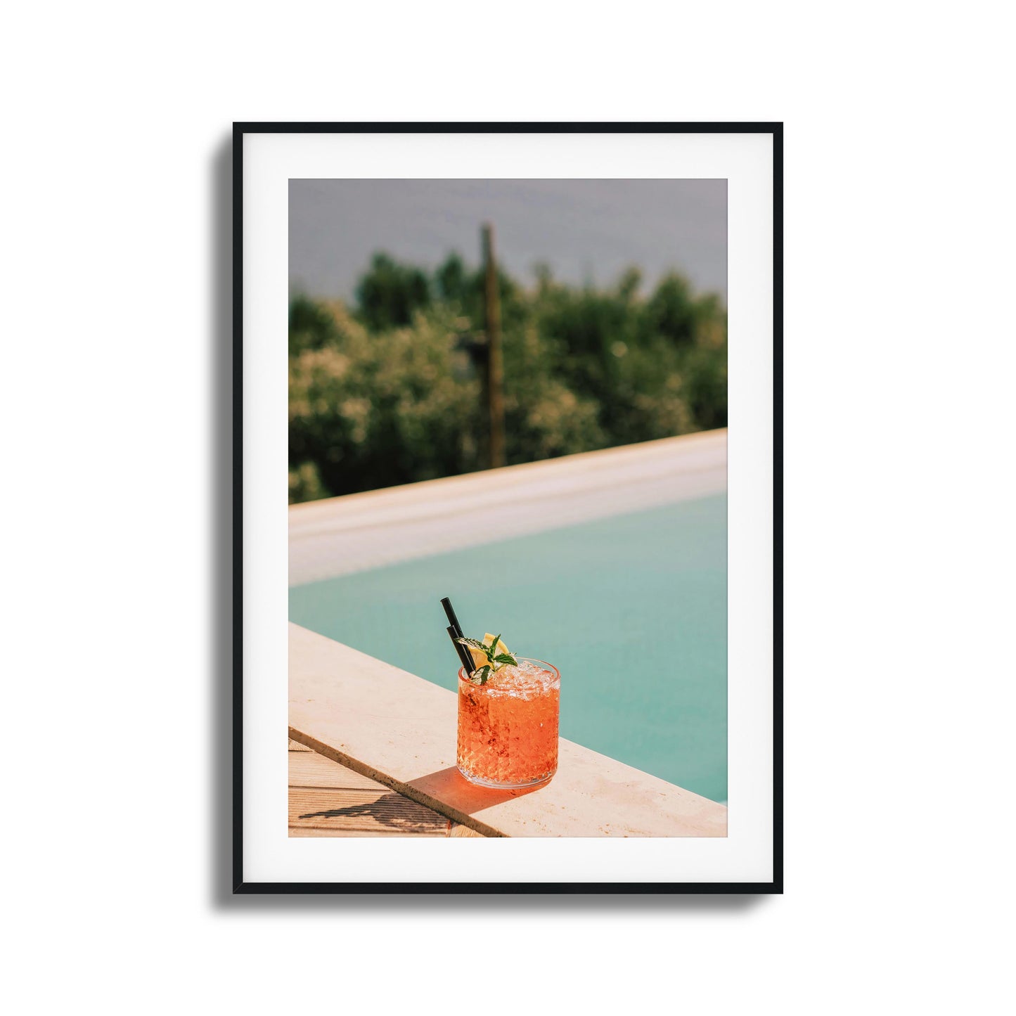 Crimson cocktail by a poolside ledge with sunlight.