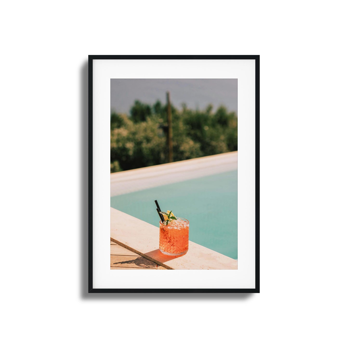 Crimson cocktail by a poolside ledge with sunlight.