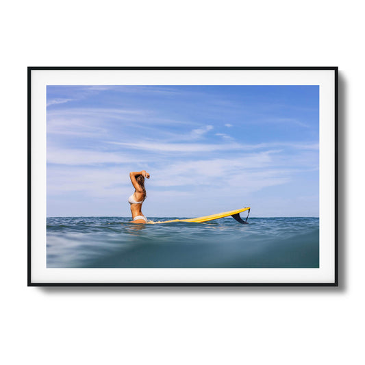 Woman with surfboard relaxing in open water framed art