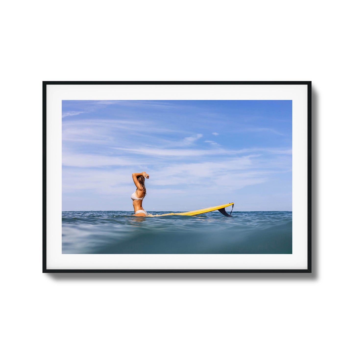 Woman with surfboard relaxing in open water framed art