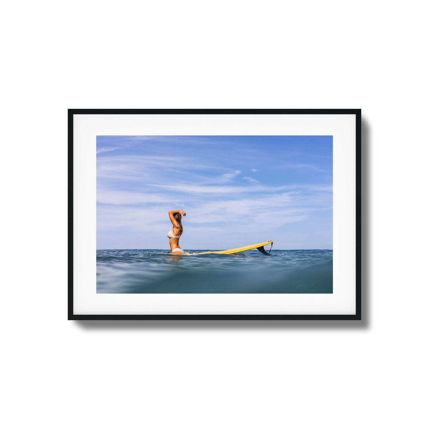 Woman with surfboard relaxing in open water framed art