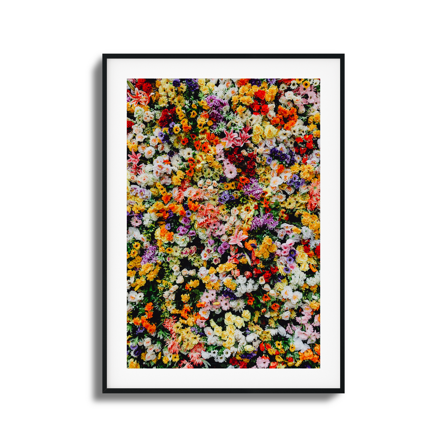 A vibrant wall of mixed colorful flowers in a stunning artistic composition.