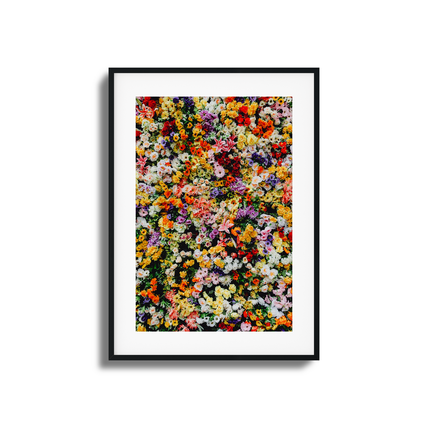 A vibrant wall of mixed colorful flowers in a stunning artistic composition.