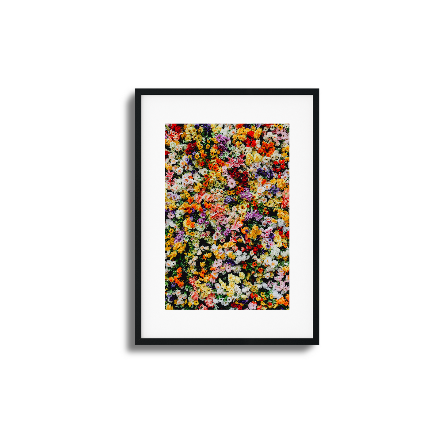 A vibrant wall of mixed colorful flowers in a stunning artistic composition.