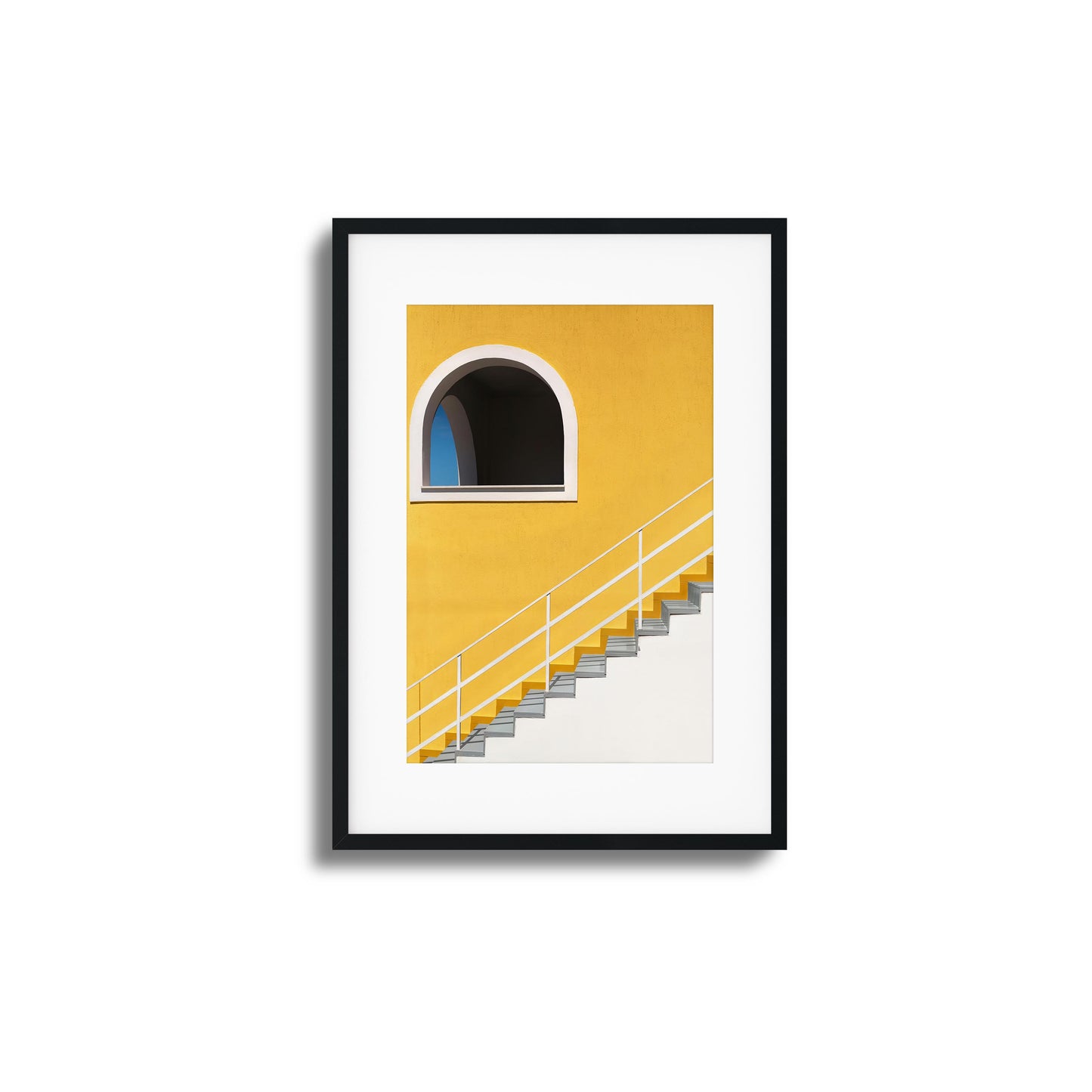 Bold yellow wall with stairs and an arched window.