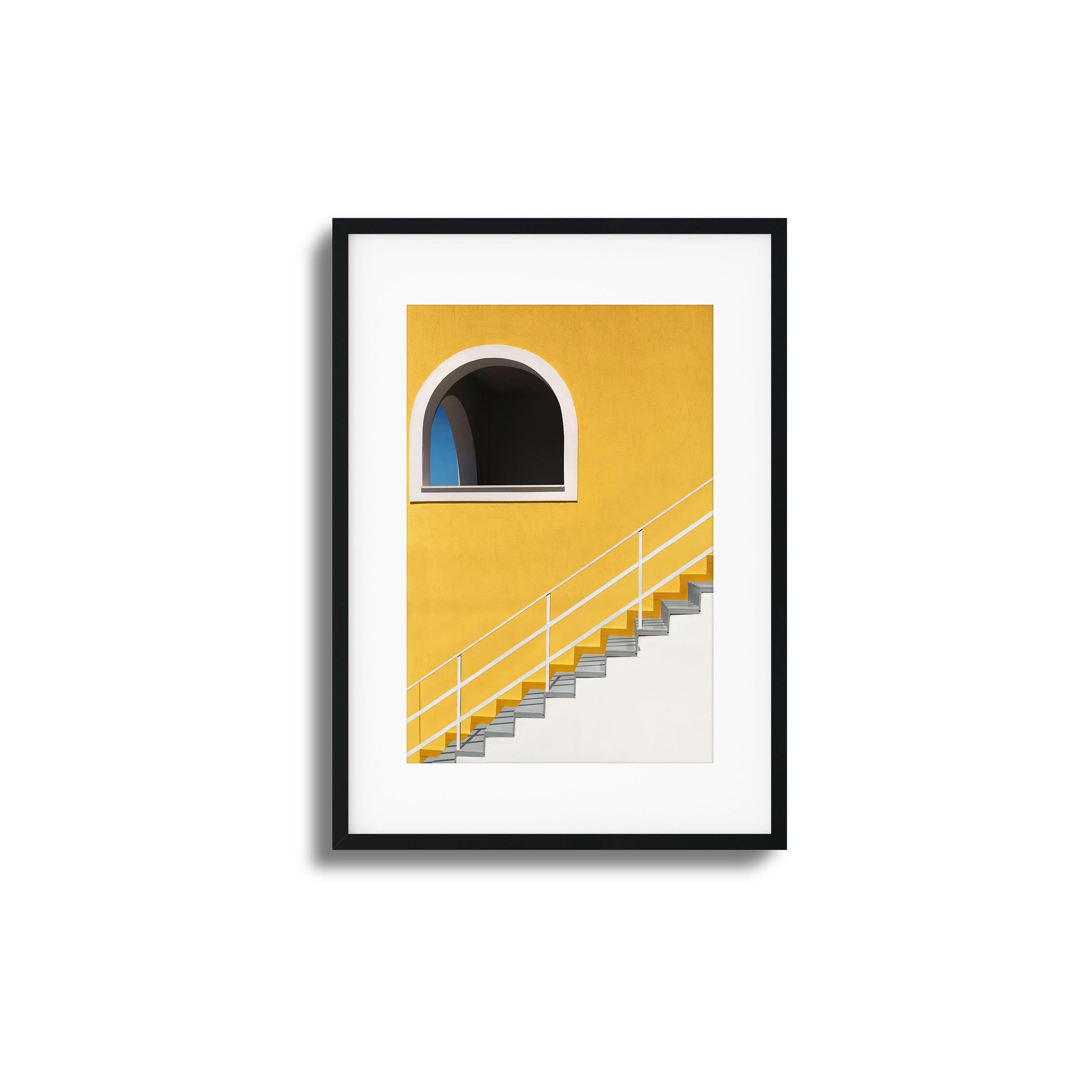 Bold yellow wall with stairs and an arched window.