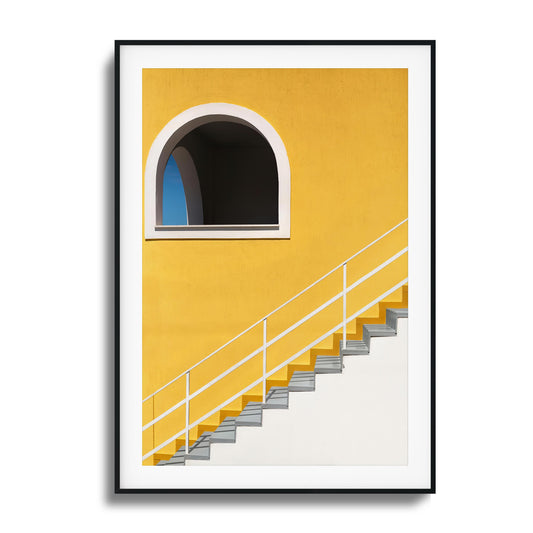 Bold yellow wall with stairs and an arched window.