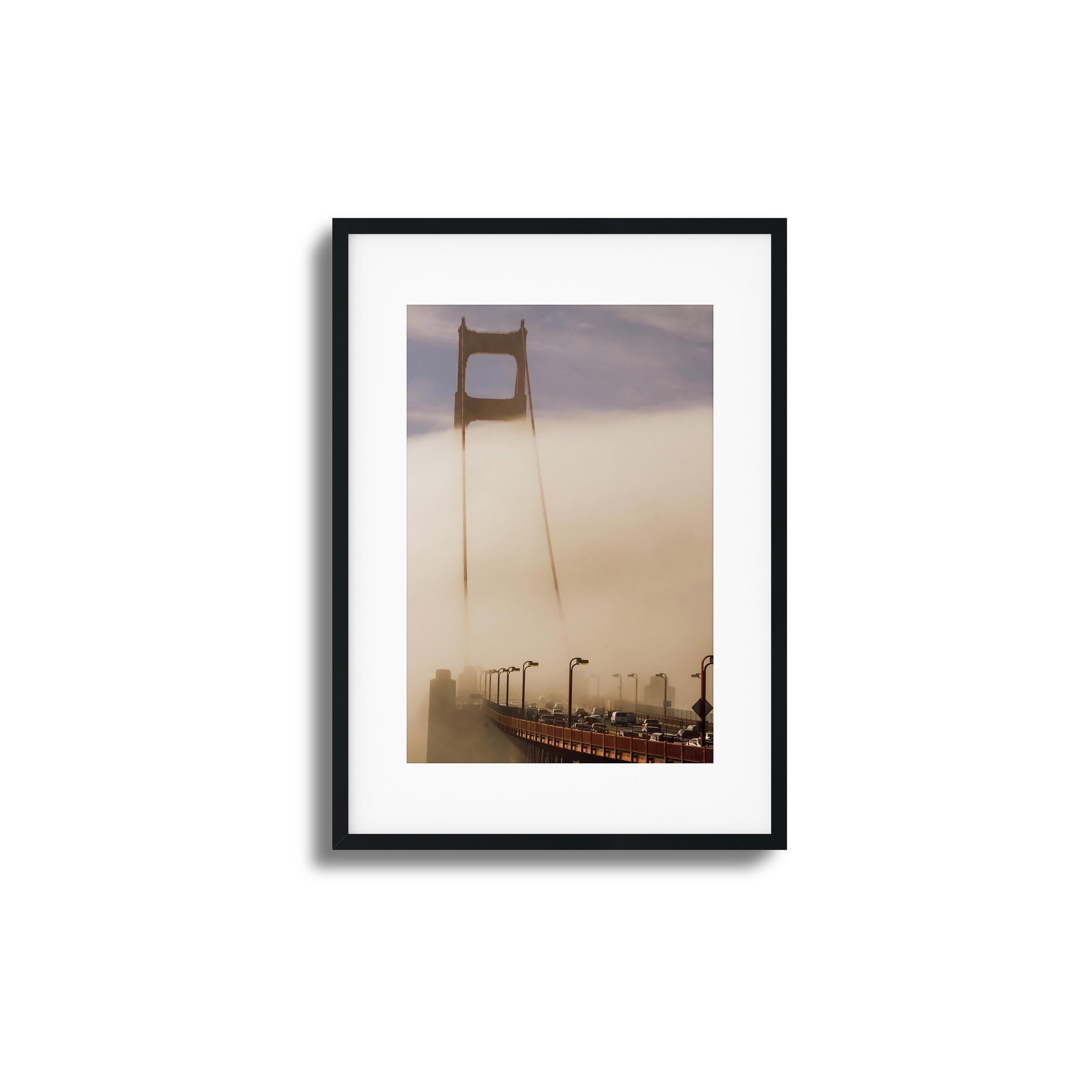 A moody photograph of the Golden Gate Bridge surrounded by dense fog, framed artwork.