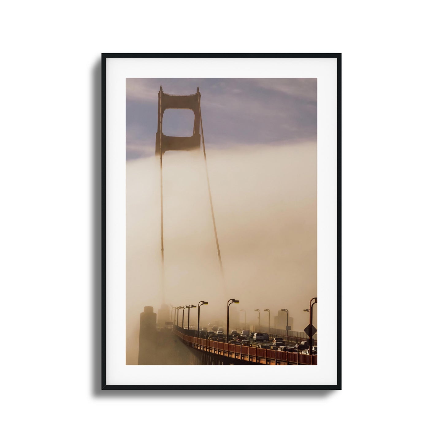 A moody photograph of the Golden Gate Bridge surrounded by dense fog, framed artwork.