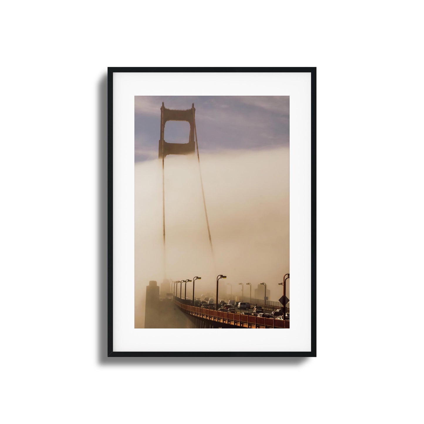 A moody photograph of the Golden Gate Bridge surrounded by dense fog, framed artwork.