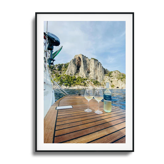 Boat deck with two wine glasses and scenic backdrop.