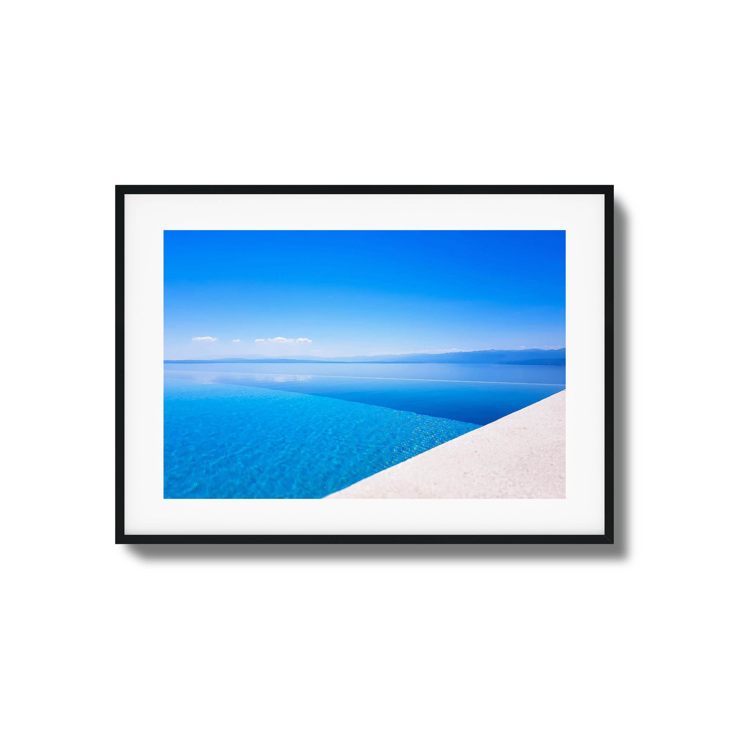 Infinity pool with crystal-clear blue water blending into the sea and distant mountains, framed art.