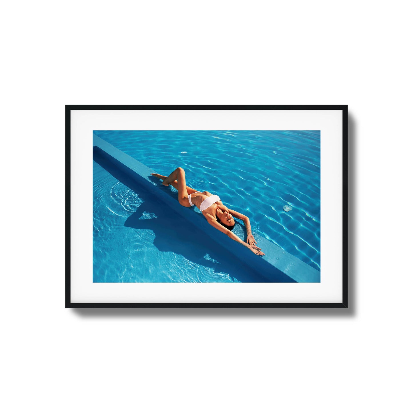 Woman relaxing poolside in bright blue water framed art