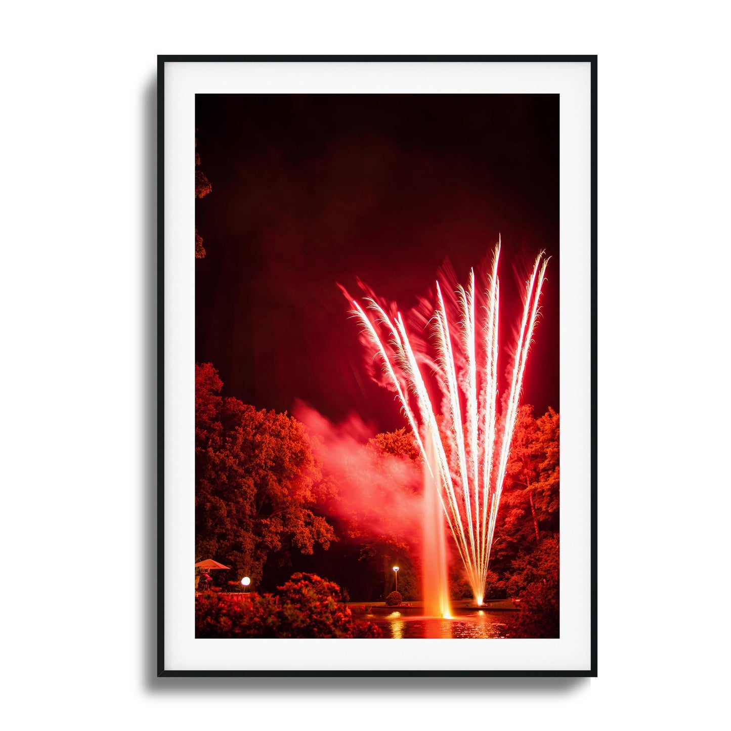 Red fireworks reflected in a pond at night