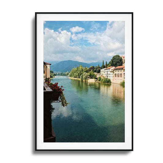 Aqua-blue river lined with colorful buildings and trees