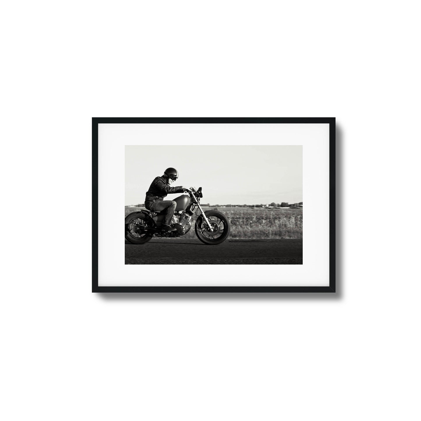 Black-and-white framed artwork of a motorcyclist in motion