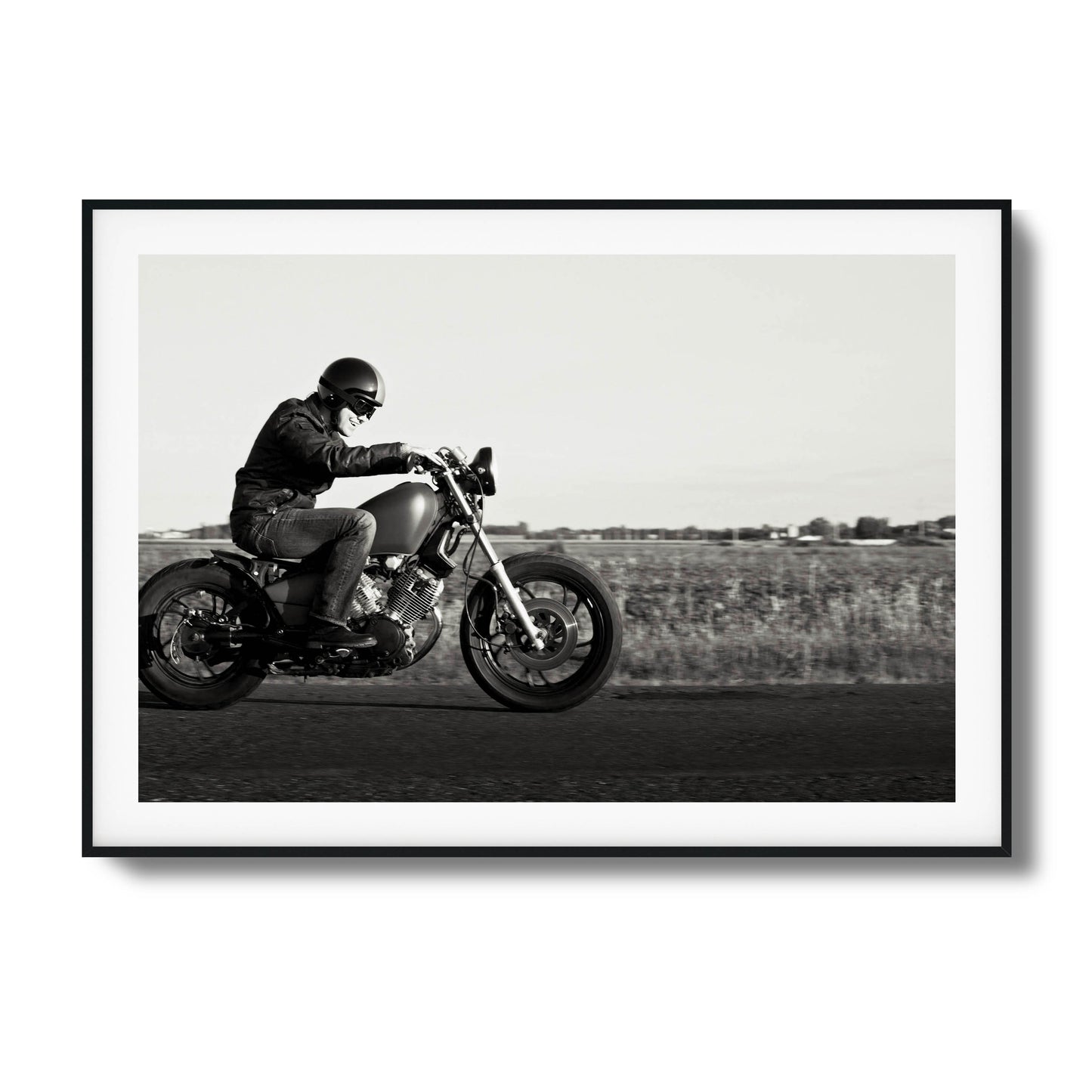 Black-and-white framed artwork of a motorcyclist in motion