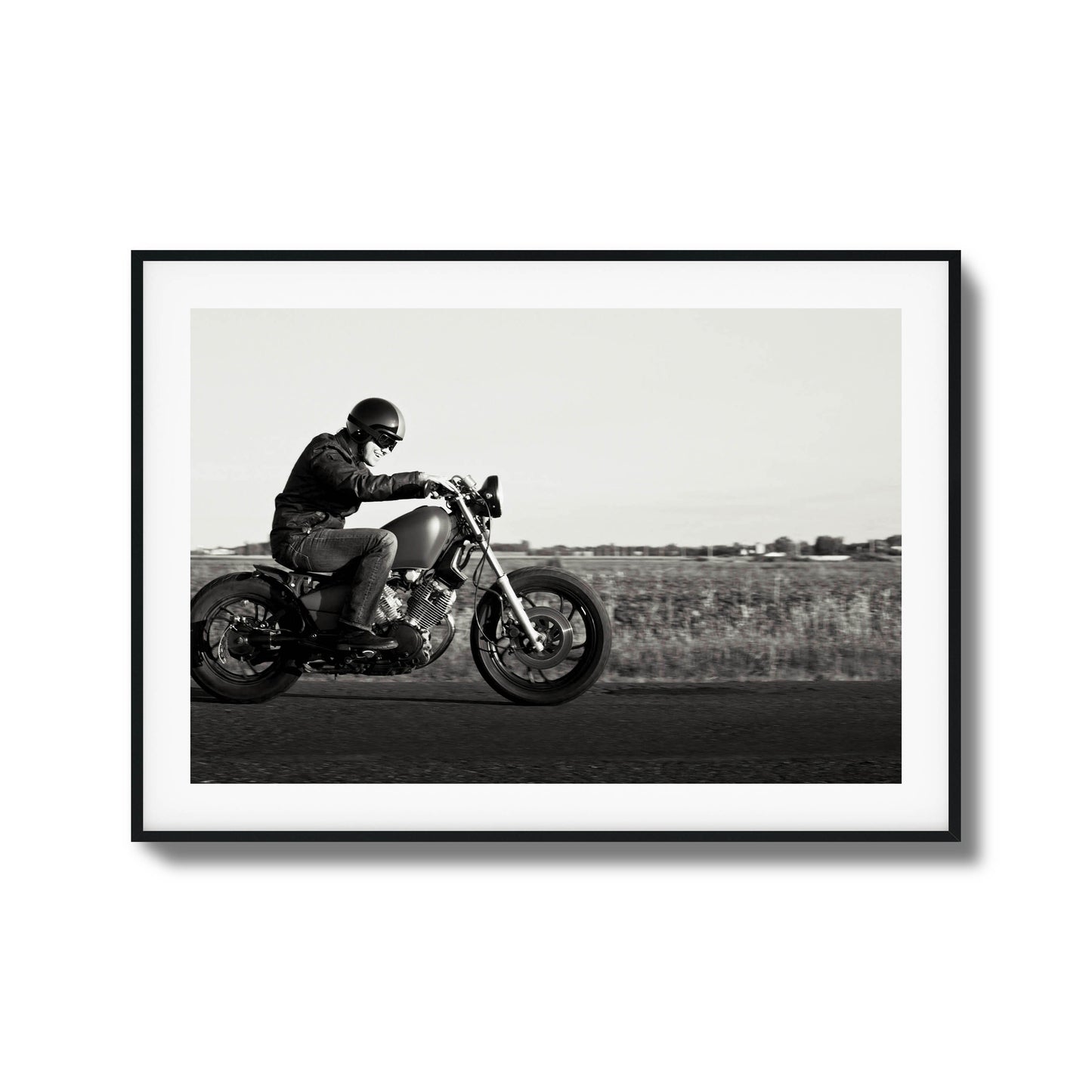 Black-and-white framed artwork of a motorcyclist in motion