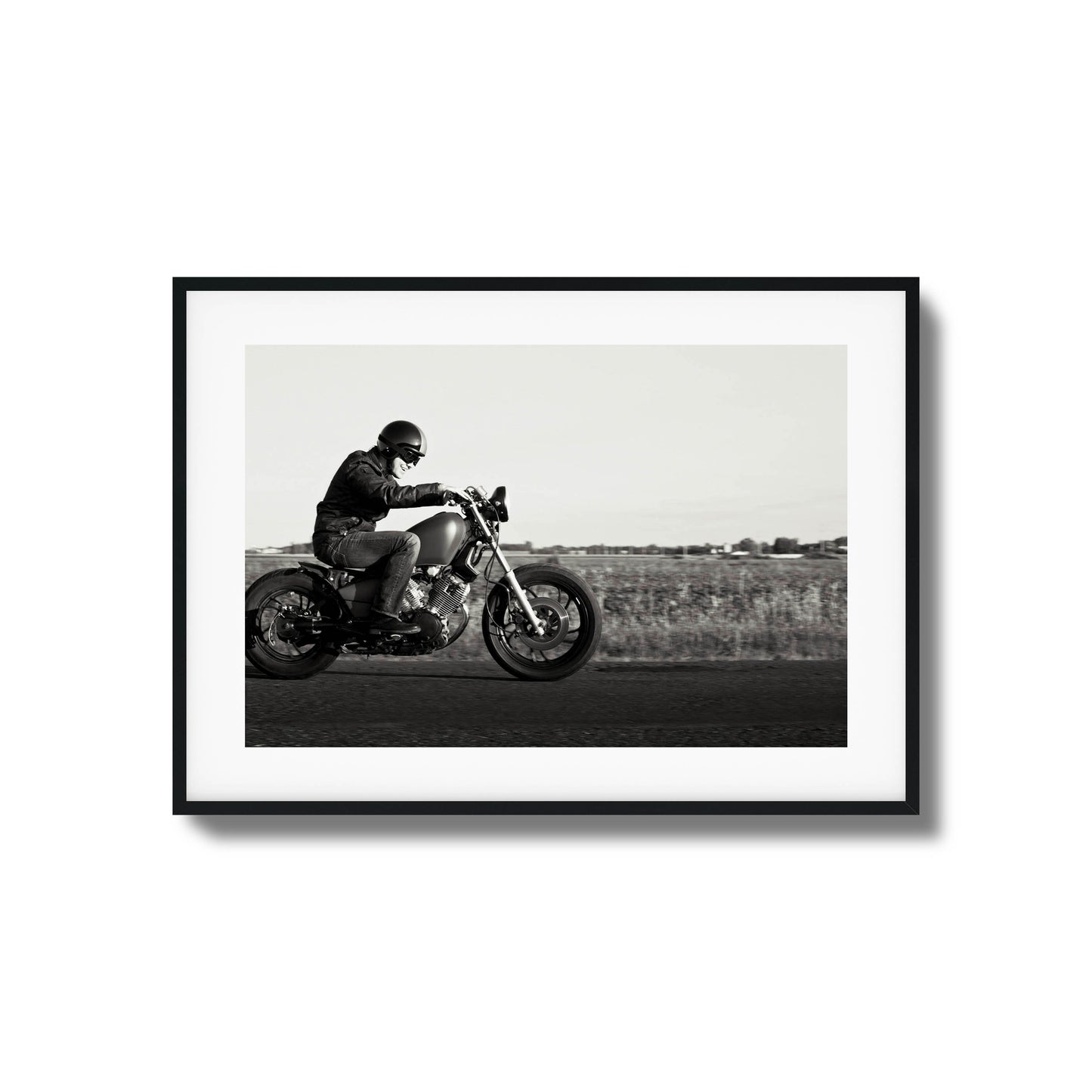 Black-and-white framed artwork of a motorcyclist in motion