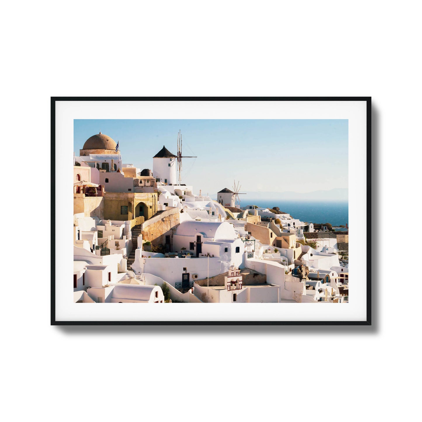 A stunning view of Santorini’s iconic white buildings and windmills under clear skies, framed art.