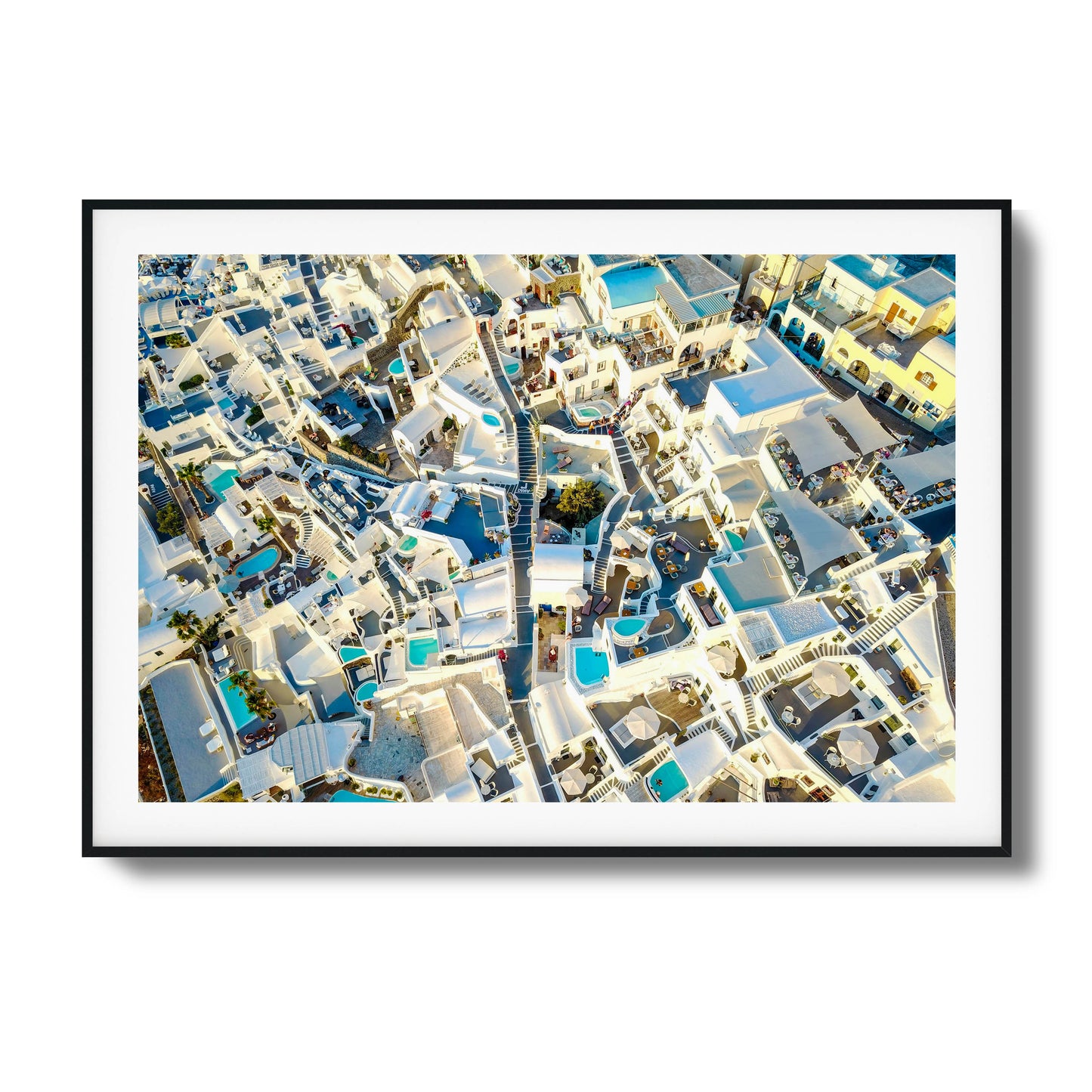 Aerial view of Santorini’s iconic white architecture with blue pools, ideal for framed wall art.