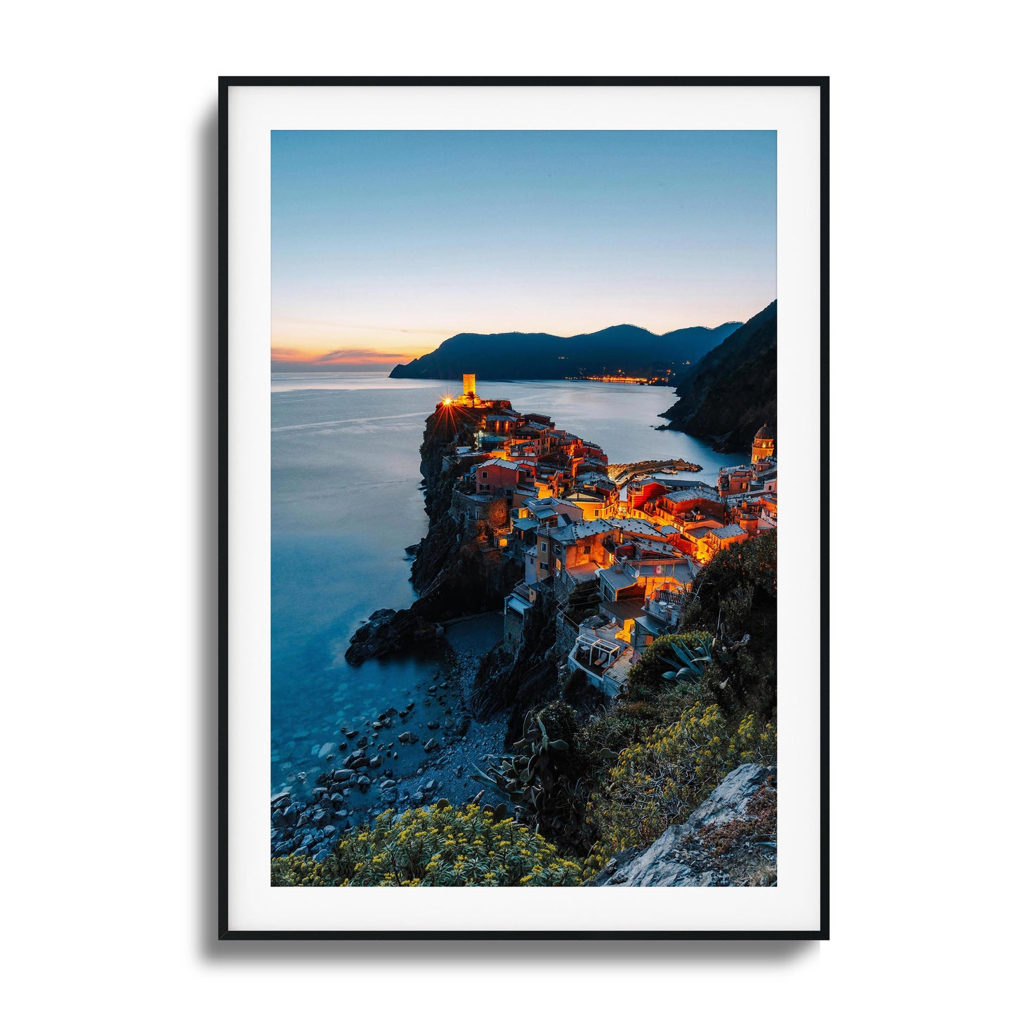 Coastal village glowing at twilight by the sea.