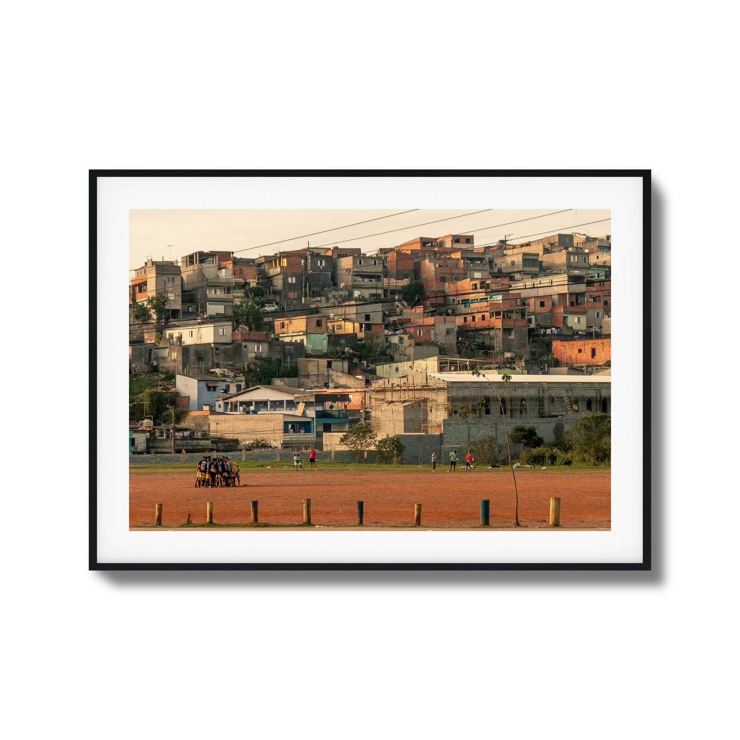 People huddled on a rust-colored field with houses.