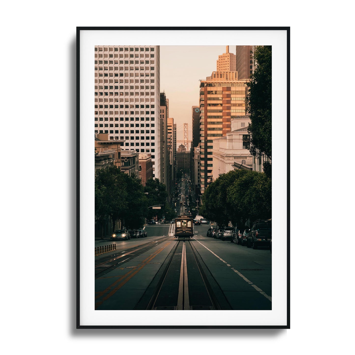 San Francisco cable car descending a hill with the city skyline in the background, framed art.