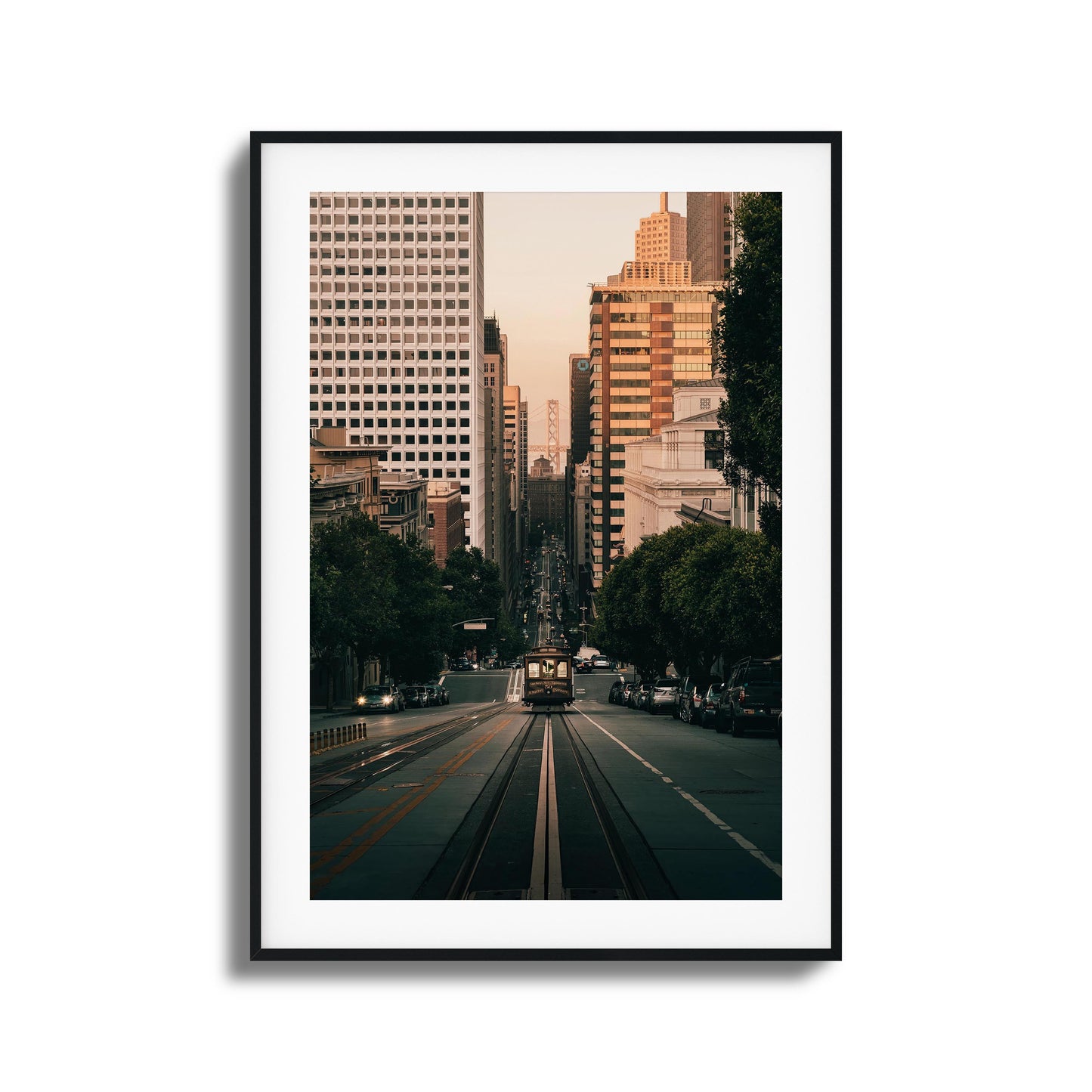 San Francisco cable car descending a hill with the city skyline in the background, framed art.