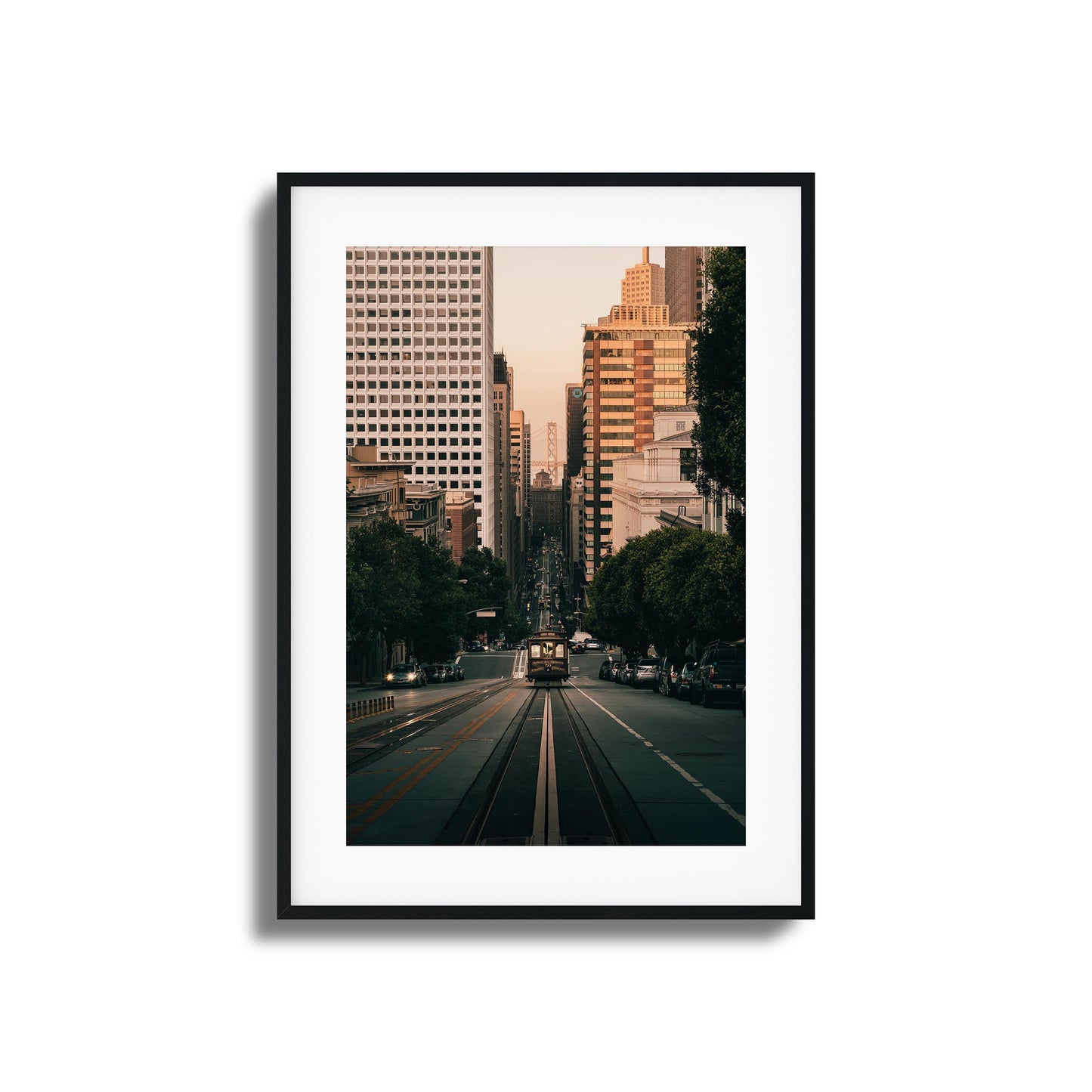 San Francisco cable car descending a hill with the city skyline in the background, framed art.