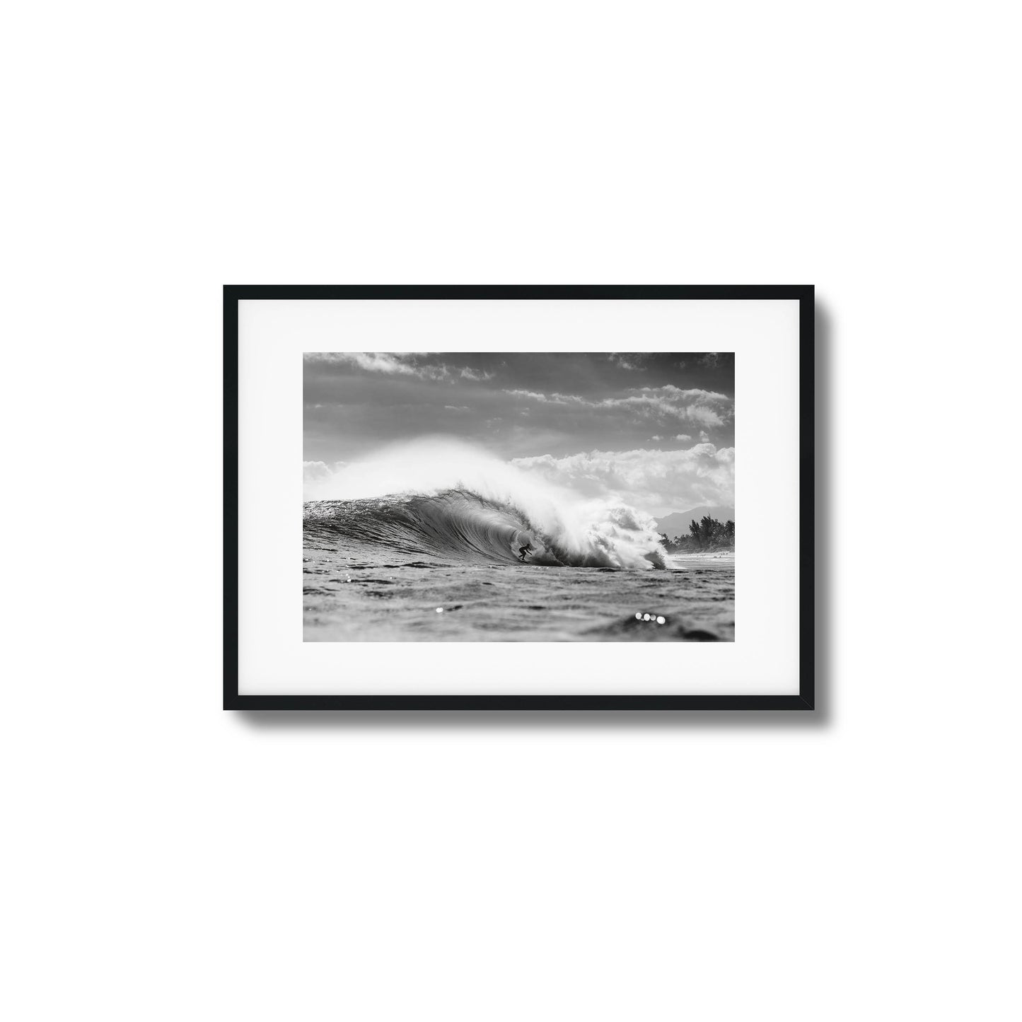 Surfer riding a large ocean wave in monochrome.