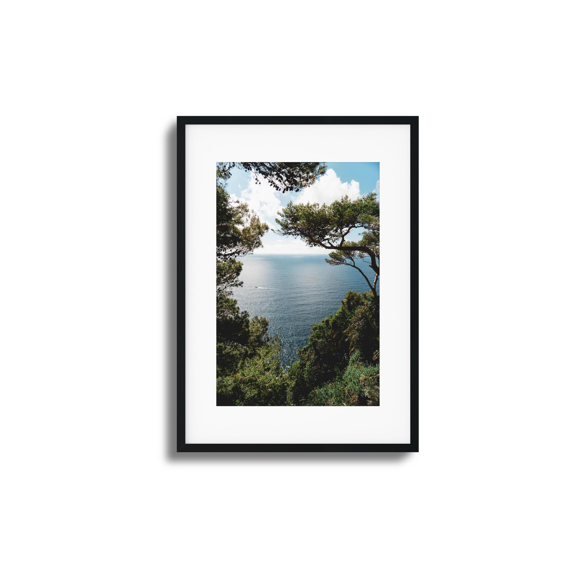 Ocean framed by lush greenery under a sunny sky, ideal for tranquil framed wall art.